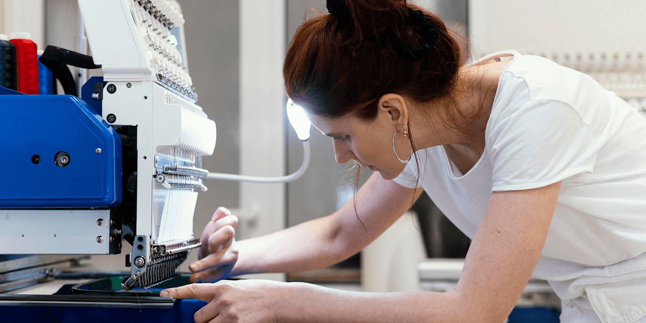 Woman working on embroidery machine